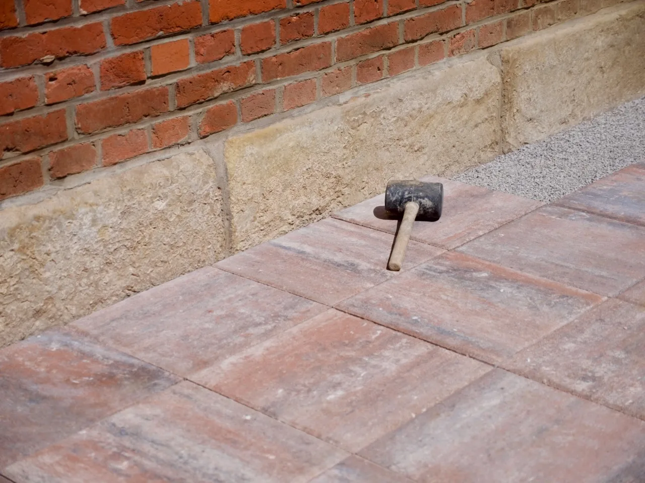 Fertig verlegte Plattenfläche entlang einer Hauswand im Garten