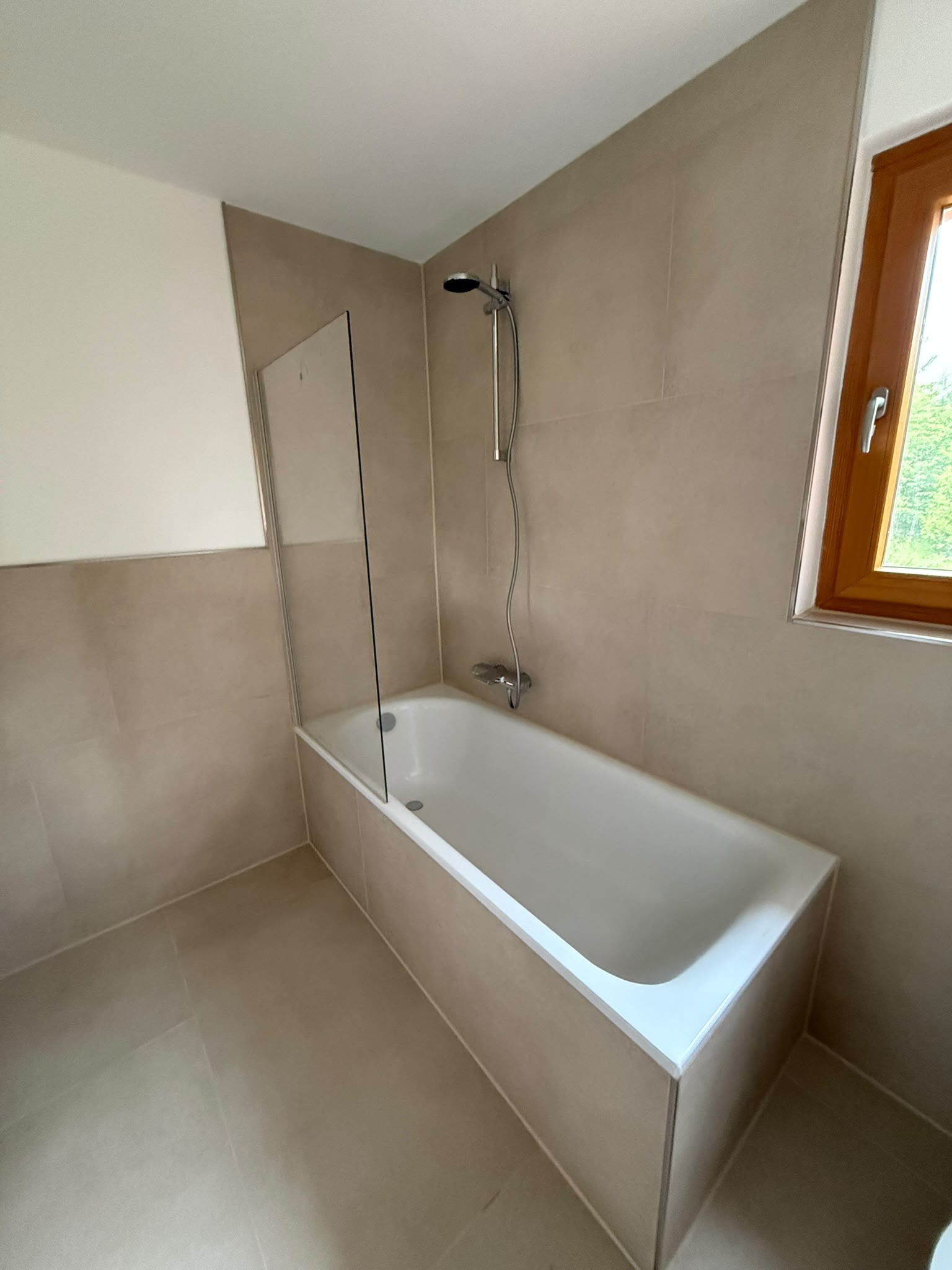 Badsanierung Lübbecke: fertig saniertes Badezimmer mit Badewanne und großformatigen Fliesen