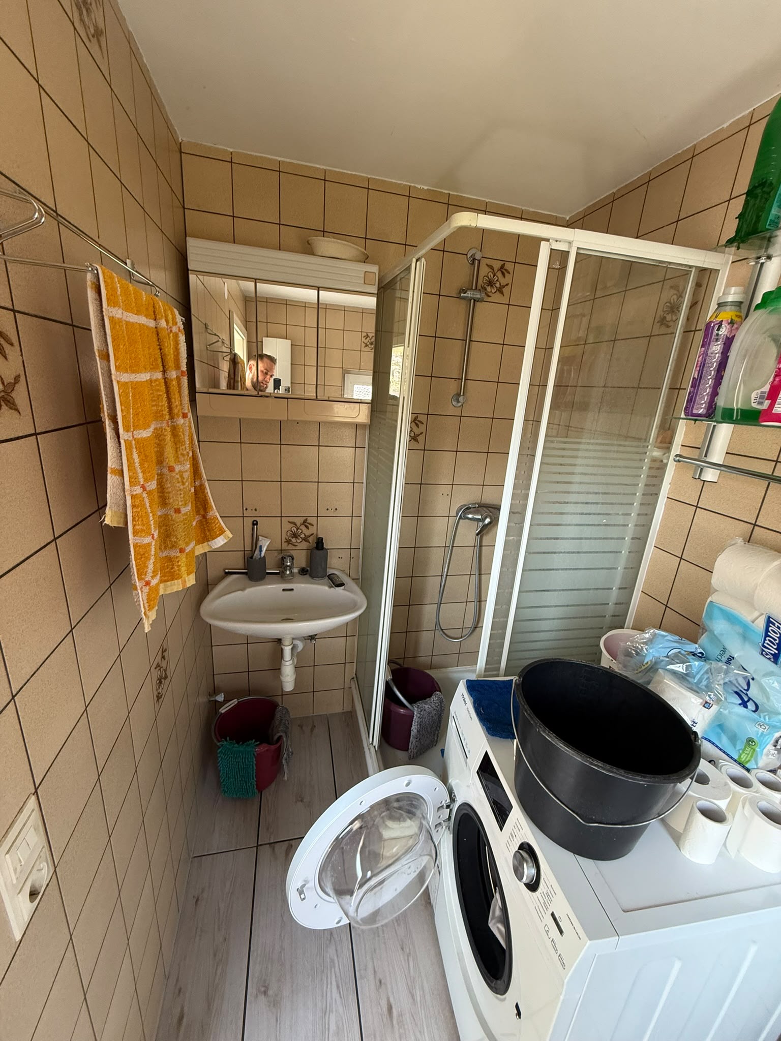 Badsanierung Lübbecke: schmales Badezimmer vor der Sanierung mit älteren Wandfliesen und Dusche